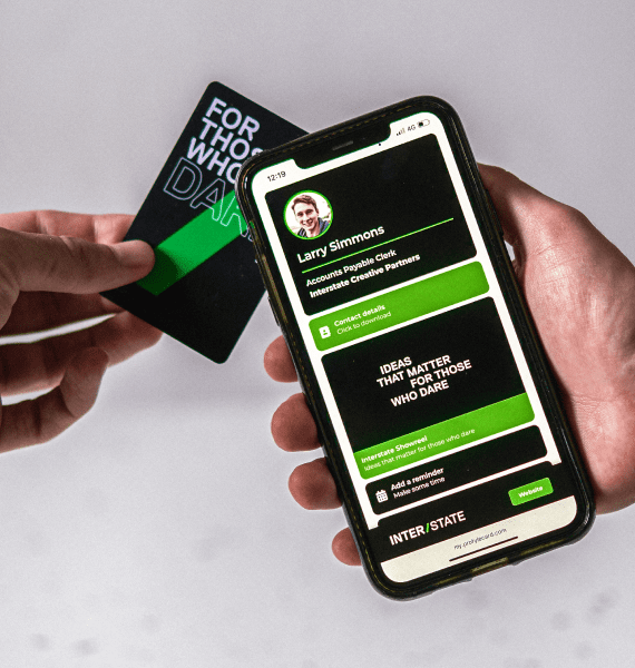 Hand holding a black card with "FOR THOSE WHO DARE" and a smartphone showing a profile for Larry Simmons from Interstate.