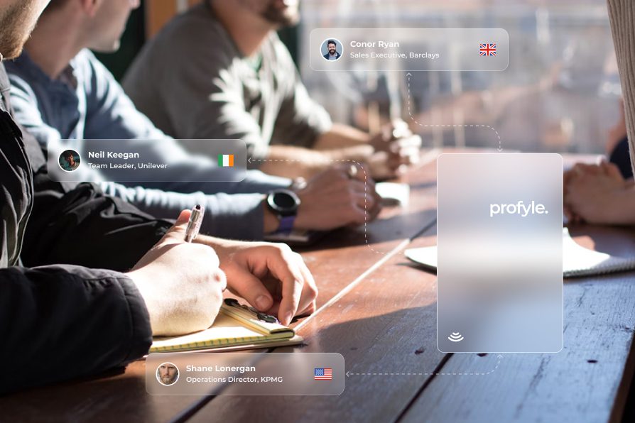 People at a table with digital overlays showing names, titles, company names, country flags, and a 'profyle.' logo.
