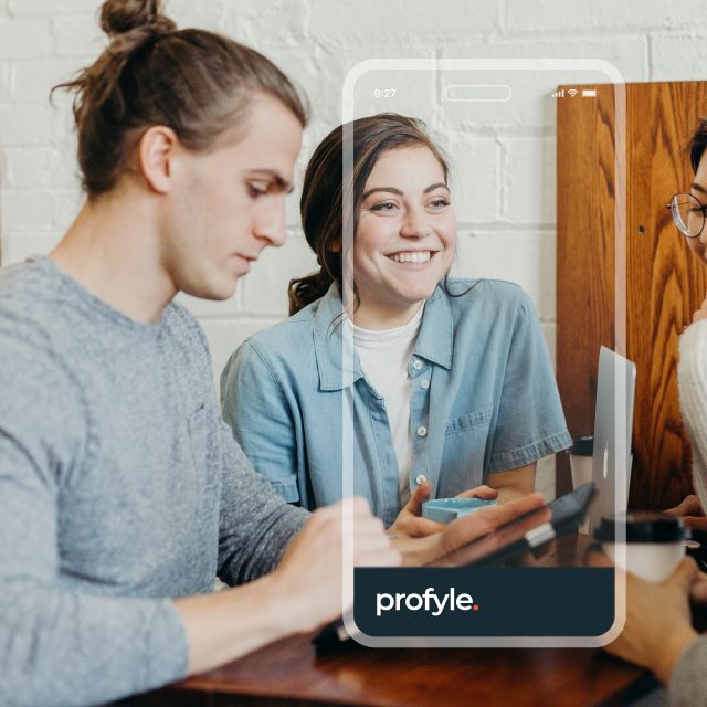Three people at a table, a smartphone overlay shows 'profyle.' text.